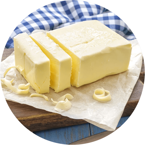 a block of real butter, sliced, on parchment and a wooden board