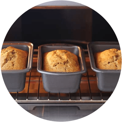 three loaves of banana bread baking side by side in the oven